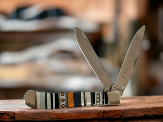 TWISTED X TWO BLADE FOLDING KNIFE WITH SERAPE HANDLE